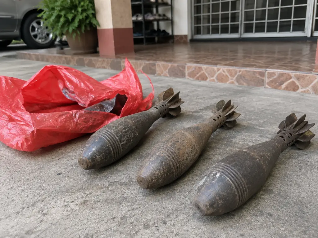 示意图：红色塑料包裹旁摆着3个疑似迫击炮弹的物体。