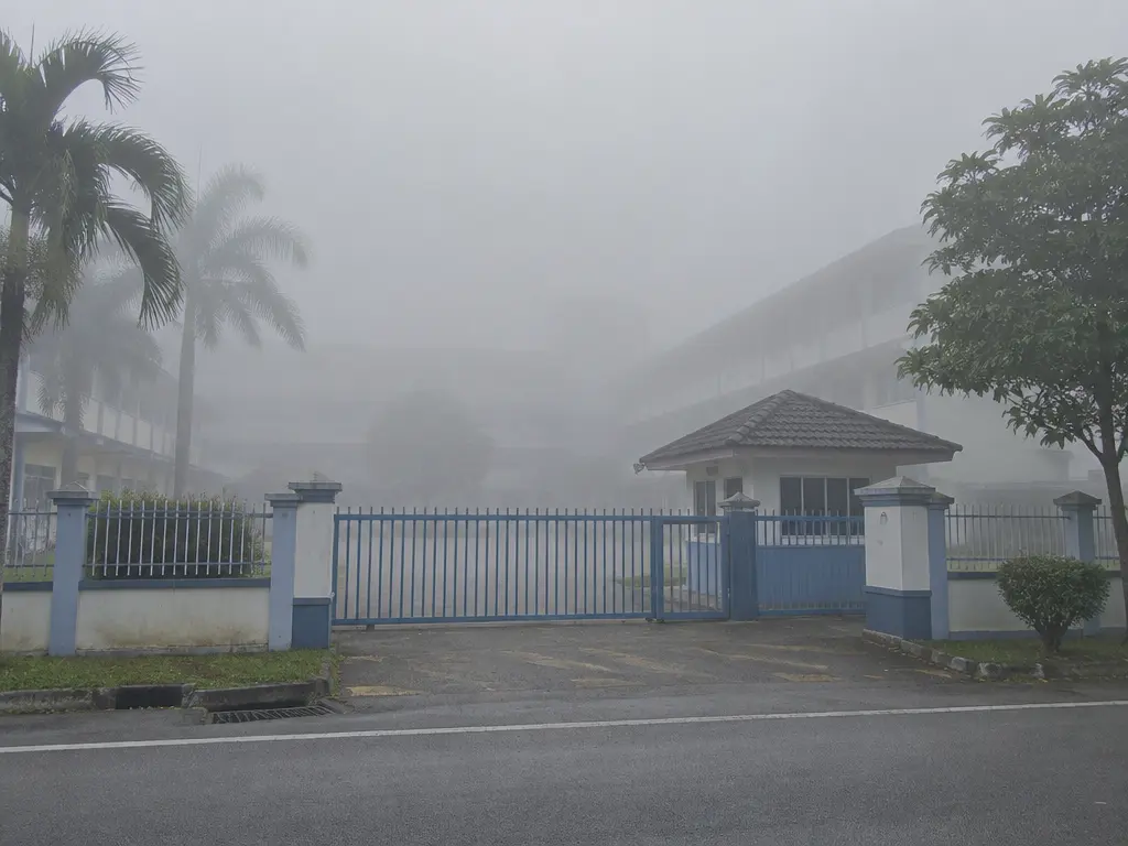 示意图:校门外望去,校园建筑几乎被灰白色浓烟霾吞没,只剩校门依稀可见